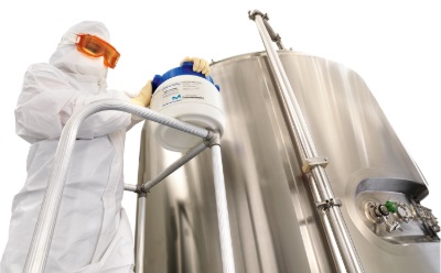 Scientist preparing media fill culture media for aseptic process simulation