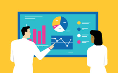 People in lab coats looking at a monitor showing different data sets, possibly analytical results