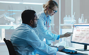 两名实验室工作人员正盯着电脑屏幕。