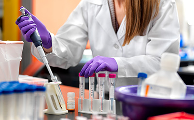 一名科学家正在锥形管中配制实验室缓冲液。