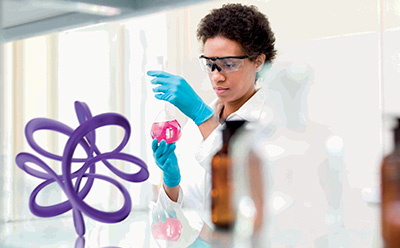 Scientist inspecting a beaker in a laboratory setting 