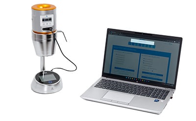 The MAS-100 Regulus Anemometer air sampler is shown alongside a laptop displaying browser-based software for wireless data transfer during calibration.