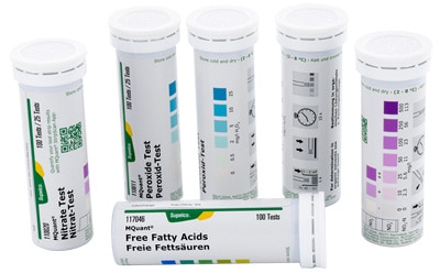  Five cylindrical containers with diagnostic test strips, each marked with different labels indicating specific tests, such as free fatty acids and other chemical indicators. The containers are variously labeled with color codes and measurement scales, suggesting they are used for specific biochemical tests.