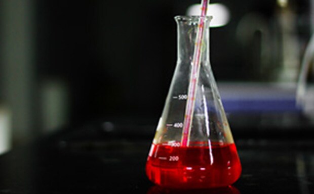 装有红色培养基的锥形瓶，锥形瓶内的培养基通过血清吸管吸取