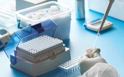 一幅实验室场景：一只戴着手套的手正用移液管将纯水吸入样品管，背景中摆放着各种实验室设备。