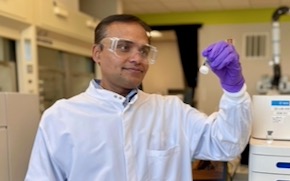 Karwa stands in lab next to an analytical instrument that helps determine the purity of mRNA.