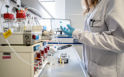 一名女性实验室科学家正在操作高通量LNP生产设备