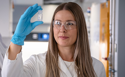 Lab worker holding glass vial