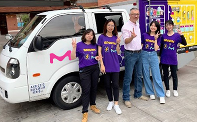 SPARK™ volunteers posing in front of company branded van.
