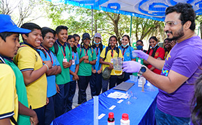 这是 SPARK™ 计划的宣传海报，海报中的小男孩身穿白大褂，戴着安全护目镜，象征着好奇心和科学探索精神。充满活力的蓝色背景上印有 "好奇心实验 "字样和 SPARK™ 徽标，邀请观众参与动手科学活动。