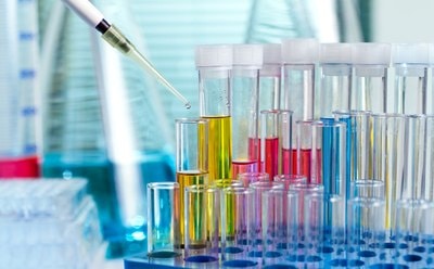 Vials of colorful biomedical polymers being filled with a pipette