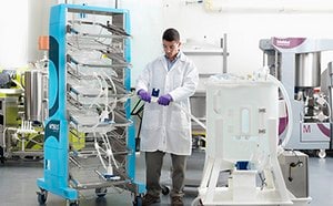 Lab technician connecting a 2D bag assembly on a Mobius® container cart to a Mobius® mixer